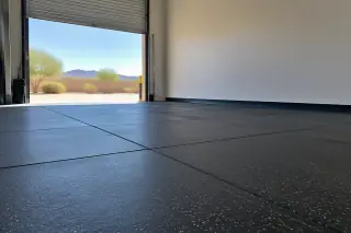 Rubber flooring installed near a warehouse roll-up door and stucco wall in Mesa, AZ.
