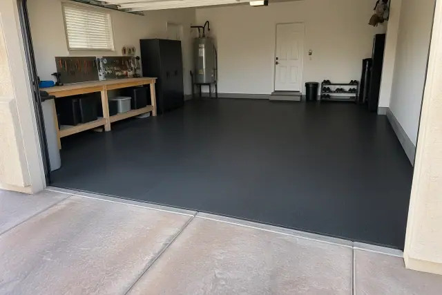 Heavy-duty garage rubber flooring installed in Mesa, AZ, with tight mat seams along the concrete wall.