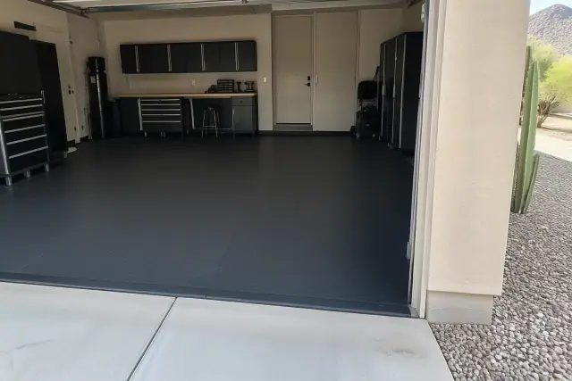 Heavy-duty rubber flooring installed in a garage with a stucco wall in Paradise Valley, AZ.