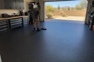 Service professional cleaning heavy-duty rubber roll flooring in a Mesa, AZ garage.