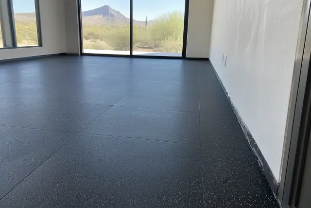 Interlocked black rubber gym flooring installed along a stucco wall in Paradise Valley, AZ.