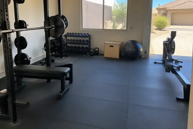 Interlocking rubber floor tiles installed in a home gym basement in Mesa, AZ, with a window view.