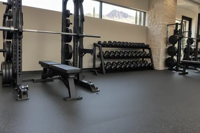 Industrial rubber flooring installed under heavy barbell racks and dumbbells in Paradise Valley, AZ.