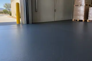Industrial rubber flooring near a stucco warehouse wall and loading dock in Mesa, AZ.