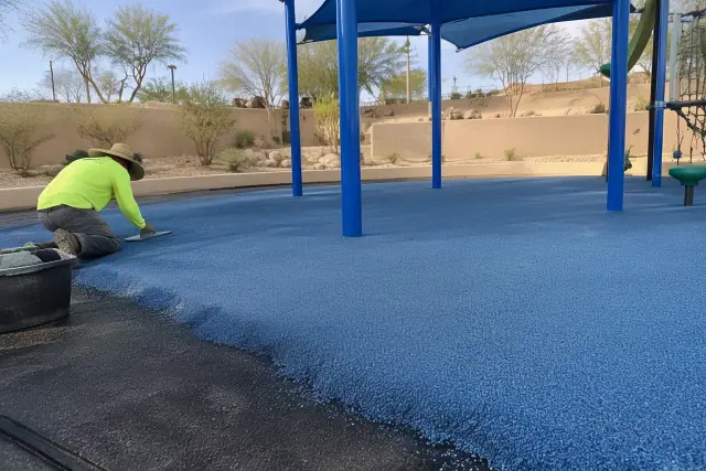 Poured-in-place rubber safety surfacing at a park in Mesa, AZ, with desert landscaping in the background.