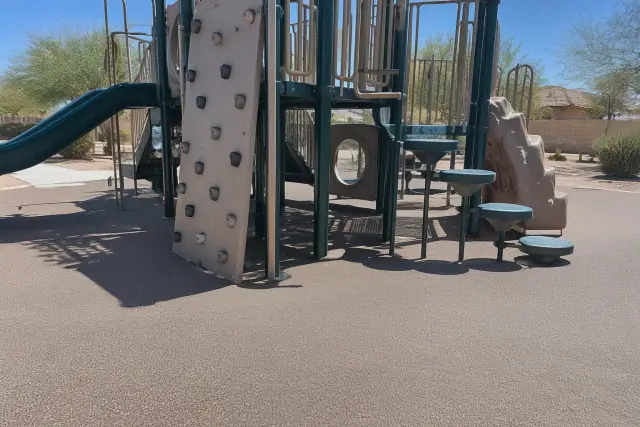 Poured-in-place rubber safety surfacing under a playground climbing set in Chandler, AZ.