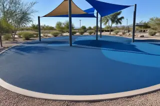 Poured-in-place rubber safety surfacing installed in a sunny park in Mesa, AZ.