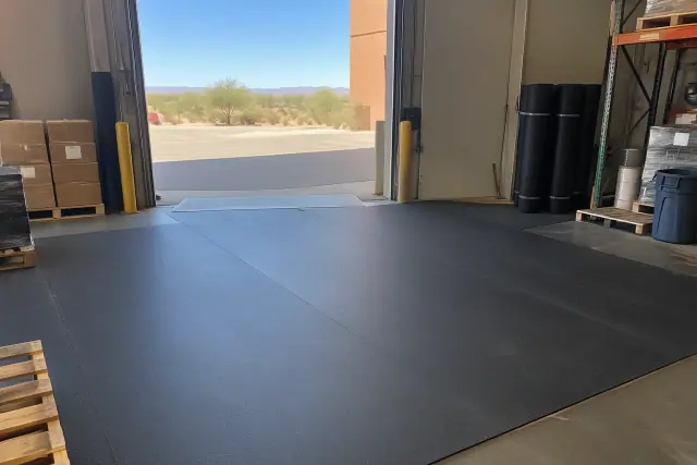 Rolled rubber flooring installed at an industrial warehouse packing station in Mesa, AZ.