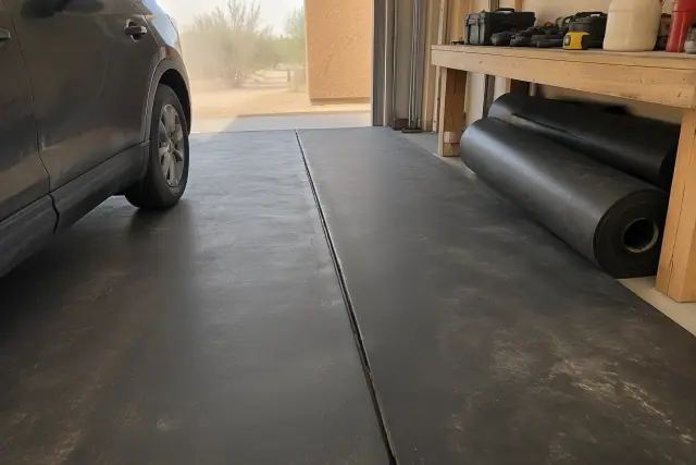 Rolled rubber flooring seams and parked car inside a garage in Mesa, AZ.
