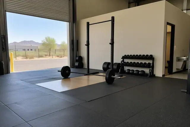 Rubber flooring replacement with interlocked tiles around a barbell platform in Mesa, AZ.