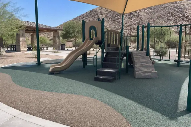 Poured-in-place rubber safety surfacing beneath a playground structure at a park in Mesa, AZ.