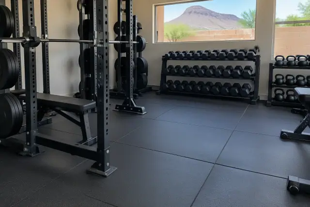 Thick rubber gym flooring installed under barbell racks in Mesa, AZ.