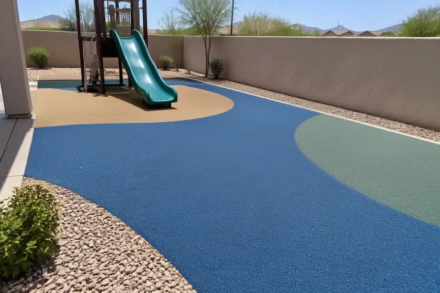 Recycled rubber surface installation with a desert gravel border and stucco wall in Mesa, AZ.
