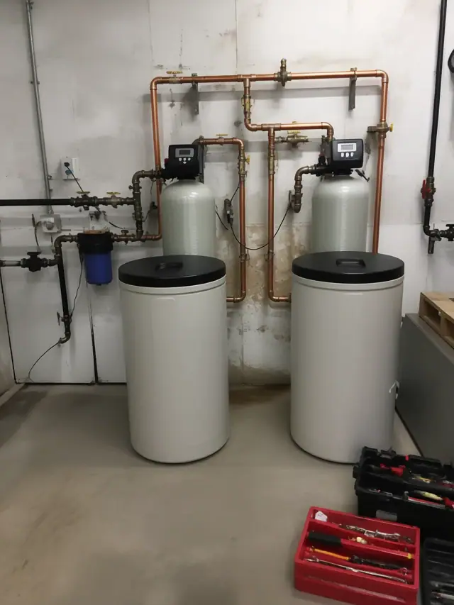 Commercial water softener installation with copper piping in a Glendale, AZ retail service room.