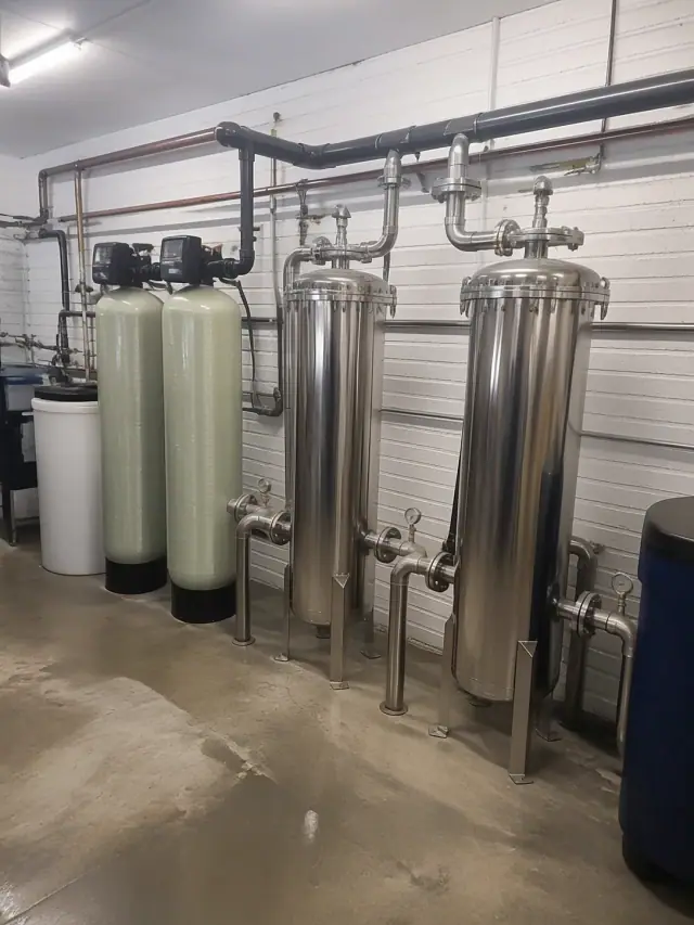 Industrial pretreatment filtration system with stainless steel tanks and piping in a commercial utility room, Mesa, AZ.