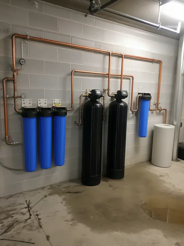 Multi-stage commercial water filtration system with copper piping installed in a utility room in Mesa, AZ.