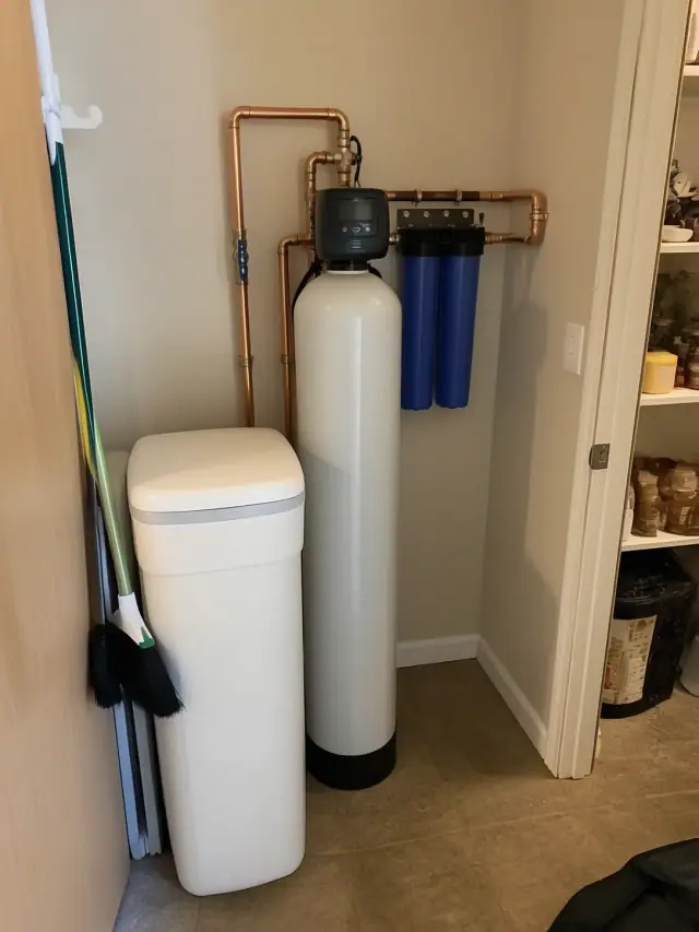 Newly installed water softener and carbon filtration system with copper piping in a Chandler, AZ home pantry.