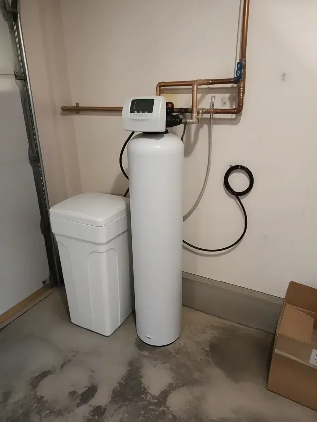 Whole-house water softener installation with copper piping in a garage in Mesa, AZ.