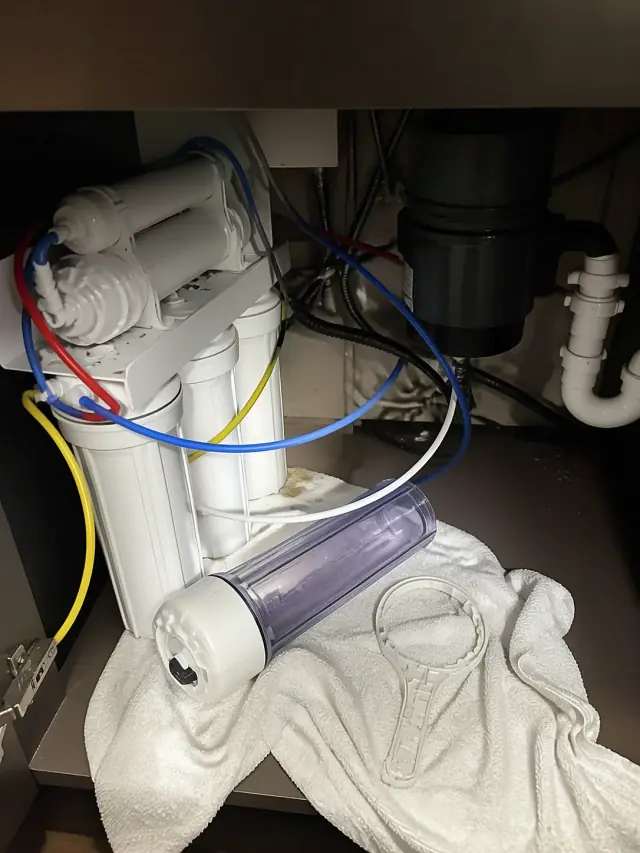 Reverse osmosis system repair under a kitchen sink cabinet in Mesa, AZ.