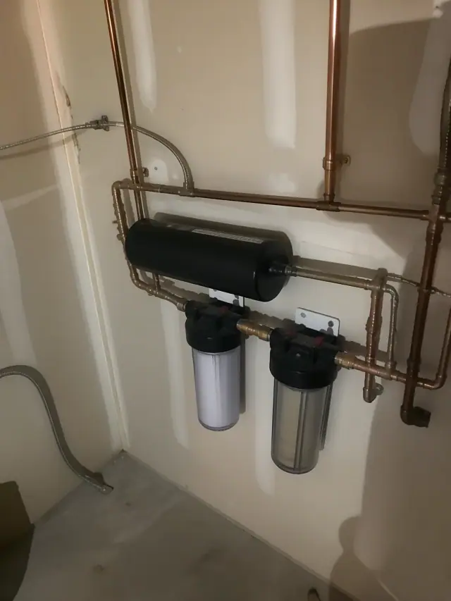 Saltless water softener installed with copper piping in a Scottsdale, AZ apartment utility room.