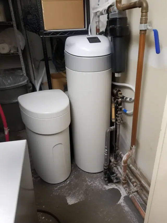White water softener tank and copper plumbing in a restaurant utility room in Apache Junction, AZ.