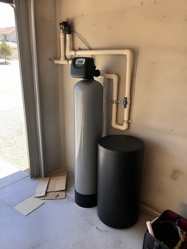 Saltless water softener system installed on a garage wall in Mesa, AZ.