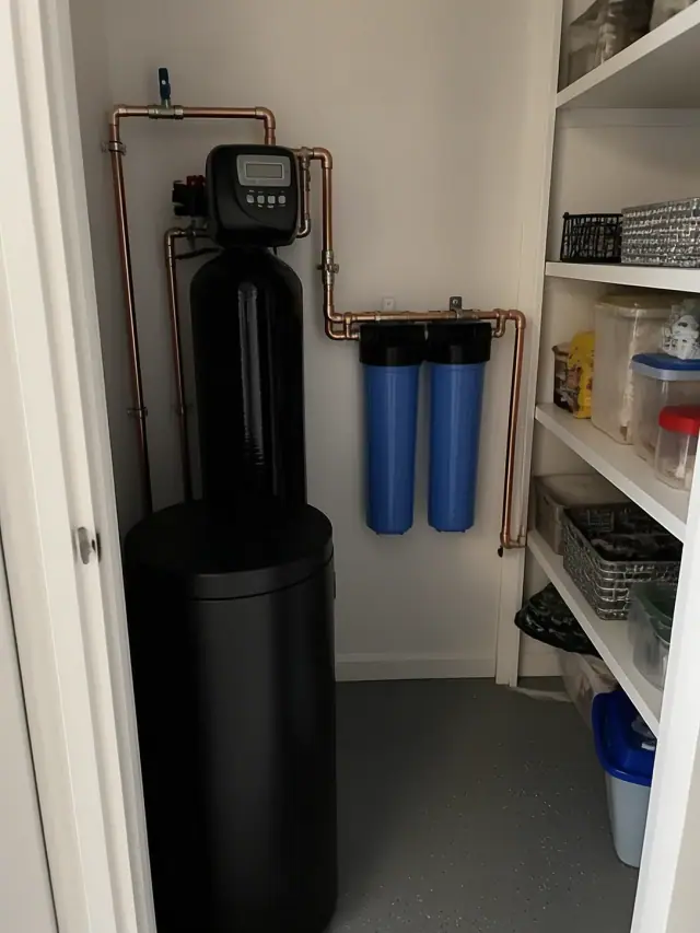 Newly installed water softener and carbon filtration system with copper piping in a Queen Creek, AZ home pantry.