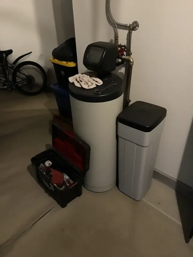 Water softener unit with tools and rags on top in a garage in Mesa, AZ.