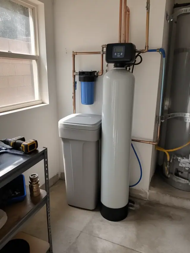 Water softener and filtration system with copper and PEX pipes installed in a Glendale, AZ garage.