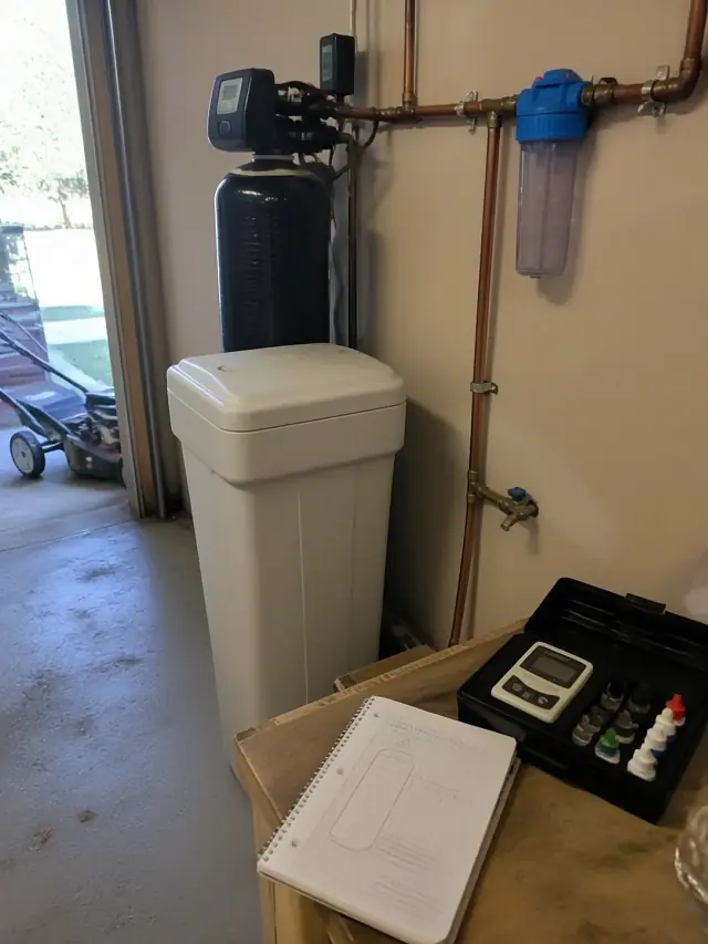 Water filtration system installed in a residential garage in Mesa, AZ, with copper piping and a brine tank.