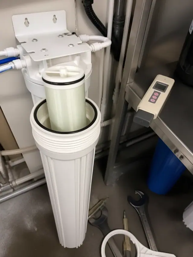 Water filtration system maintenance in a Mesa, AZ office utility room showing a new membrane and digital TDS meter.