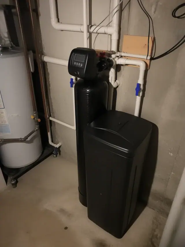 Newly installed water softener and filter system with clean PVC piping in a residential mechanical room in Mesa, AZ.