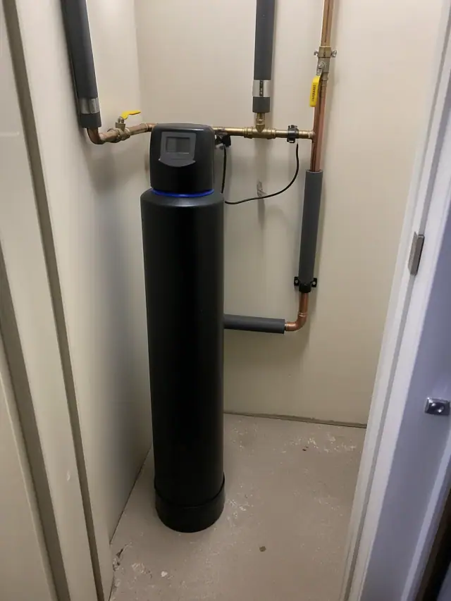 Saltless water softener installation with copper piping in a mechanical room in Peoria, AZ.