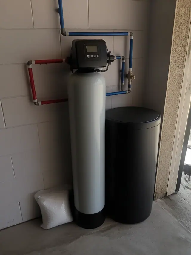 Water softener installation with PEX piping and a bag of salt in a Mesa, AZ garage.