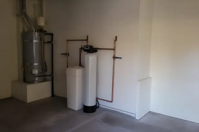 Water softener system installed with copper piping next to a water heater in a Mesa, AZ residential garage.