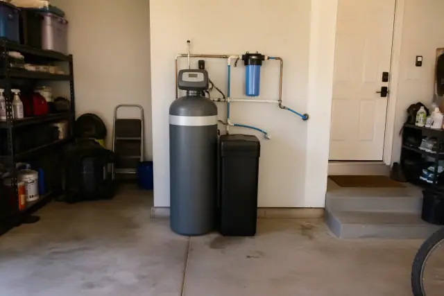 Newly installed water softener system with PEX piping in a residential garage in Mesa, AZ.