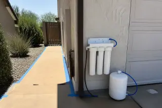 Reverse osmosis system with clean tubing installed near a garage in Mesa, AZ.
