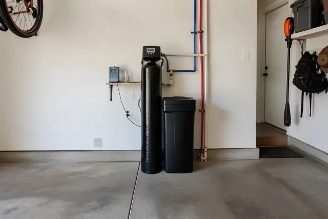 Water softener system installed with PEX plumbing in a residential garage in Mesa, AZ.