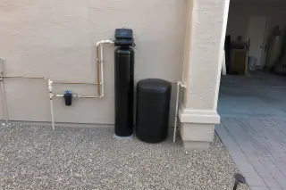 Finished water softener system installed against a stucco wall at a home in Mesa, AZ.