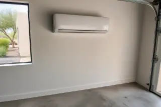 Indoor mini split unit mounted on a finished wall with refrigerant lines in a Phoenix, AZ garage.