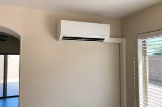 Cleaned indoor mini split unit with bright sunlight on a textured wall in Phoenix, AZ.