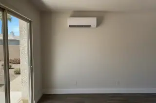 Mini split indoor unit installed on a wall with refrigerant lines in Phoenix, AZ.
