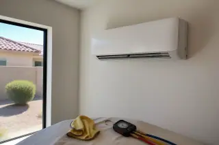 Indoor mini split unit with cleaning cloth and pressure gauge on a drop cloth in a Phoenix, AZ home.