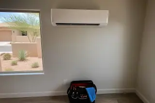 Indoor mini split unit mounted on a wall with a toolkit on the floor in a Phoenix, AZ home.