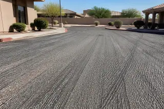 Textured cross-hatched surface of a milled asphalt parking lot in Peoria, AZ with desert landscaping in the background.