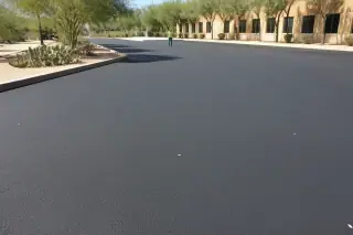 Technician inspecting a finished asphalt parking lot with prickly pear cacti in Peoria, AZ.