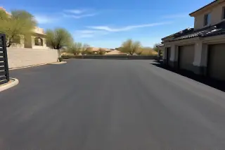 Wide view of a newly installed asphalt driveway next to a stucco house in Peoria, AZ.