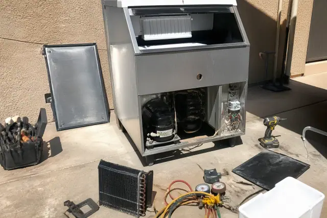 Commercial ice machine repair on a staging floor near a stucco wall in Phoenix, AZ.
