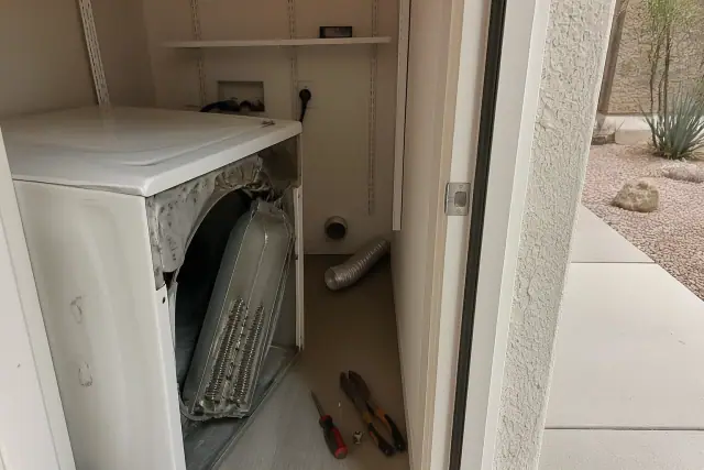 Dryer repair in progress with tools and exposed heating element in a Tempe, AZ laundry closet.