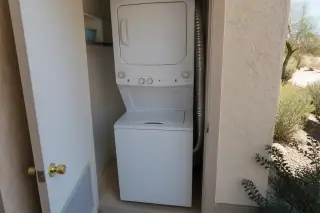 Reassembled dryer unit with a secured vent hose in a laundry closet, Phoenix, AZ.